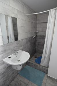 a bathroom with a white sink and a shower at Vila 69 in Costinesti