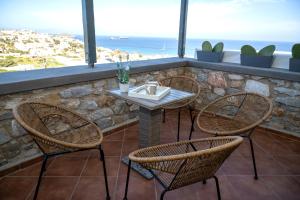 una mesa y sillas en un patio con vistas al océano en Aegean Suite, en Azolimnos