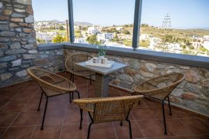 a table and chairs on a patio with windows at Aegean Suite in Azolimnos