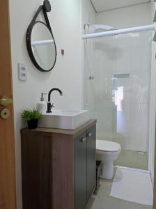 a bathroom with a sink and a toilet and a mirror at Loft Giese in Navegantes
