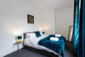 um quarto com uma cama com um cobertor azul em Staywhenever HS- 4 Bedroom House, King Size Beds, Sleeps 9 em Stoke-on-Trent