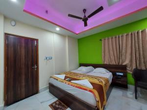 a bedroom with a bed with a purple ceiling at ICONIC Hotel Digha in Digha