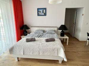 sypialnia z białym łóżkiem i 2 lampami w obiekcie Apartament SPOKOLOCO:) w Pogorzelicy