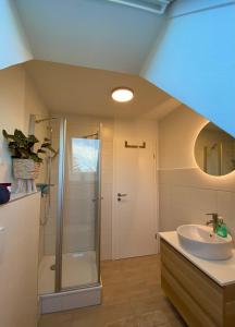 ein Bad mit einer Dusche und einem Waschbecken in der Unterkunft Inselwohnung Nordstrand in Nordstrand