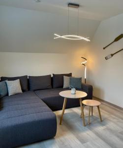 ein Wohnzimmer mit einem blauen Sofa und einem Tisch in der Unterkunft Inselwohnung Nordstrand in Nordstrand