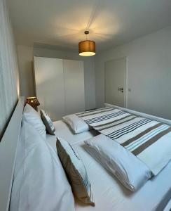 a bedroom with two beds with white sheets and pillows at Inselwohnung Nordstrand in Nordstrand