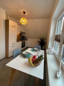 eine Küche mit einem Tisch und einer Obstschale darauf in der Unterkunft Inselwohnung Nordstrand in Nordstrand
