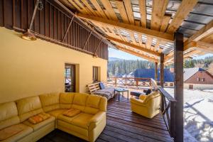 a living room with a couch on a wooden deck at Penzion Petra, Harrachov in Harrachov