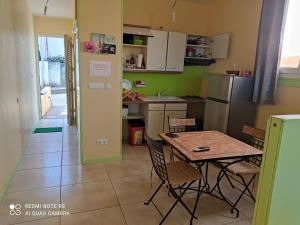 uma cozinha com mesa, cadeiras e geladeira em Anajodrey em Saint-Joseph