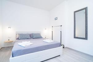 a white bedroom with a large bed with a mirror at Apartment Olive in Dubrovnik