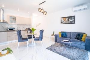 uma sala de estar com um sofá azul e uma mesa em Apartment Olive em Dubrovnik