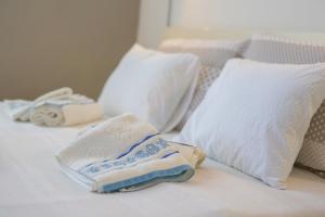 ein weißes Bett mit weißen Kissen und Handtüchern darauf in der Unterkunft Studio Apartment Vesna in Krk