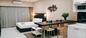 a hotel room with a bed and a kitchen with a table at Mercu Summer Suites KLCC by Star Residence in Kuala Lumpur