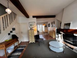 uma sala de estar com uma mesa e um piano em Maison Cosy Touquettoise em Le Touquet-Paris-Plage