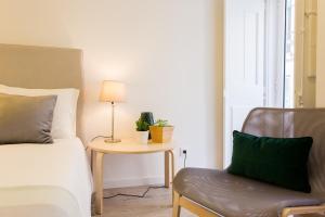 a bedroom with a bed and a table and a chair at Amalia Studios in Lisbon