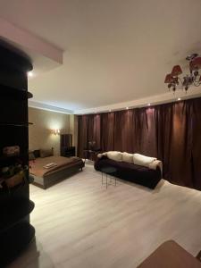 a living room with a couch and a bed at Мост Сити 7 поверх in Dnipro