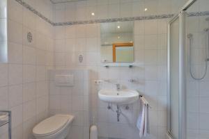 ein weißes Bad mit einem WC und einem Waschbecken in der Unterkunft Landhaus Stefanie in Mayrhofen
