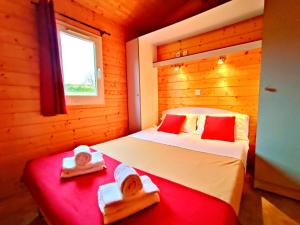a bedroom with two beds with towels and a window at LES CHALETS DE SANCERRE in Thauvenay