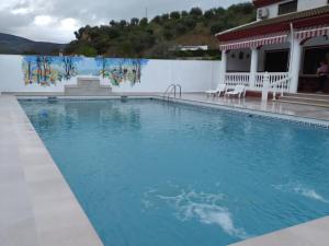 una piscina de agua azul frente a una casa en Villa Frasquita, en Priego de Córdoba