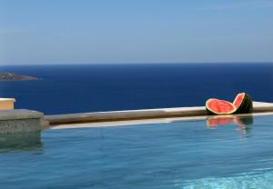 a slice of watermelon sitting on the edge of a swimming pool at Bella Mare Sitia in Sitia