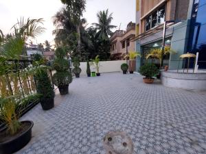 a teddy bear sitting in a courtyard with potted plants at ICONIC Hotel Digha in Digha