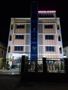 ICONIC Hotel Digha في ديغا: مبنى طويل في الليل مع مبنى