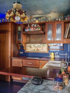 cocina con armarios de madera, fregadero y mesa en casa bioclimática, en Arafo