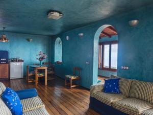 Sala de estar azul con sofá y cocina en casa bioclimática, en Arafo