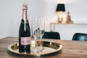 una botella de champán y dos copas de vino en una mesa en Palais Apartment direkt im Zentrum, FEWO-Residenz-Dresden, en Dresden