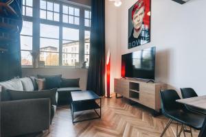 a living room with a couch and a tv at Palais Apartment direkt im Zentrum, FEWO-Residenz-Dresden in Dresden