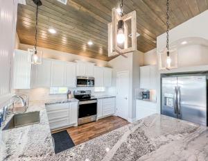 a kitchen with white cabinets and a stainless steel refrigerator at Crystal Blue home in Crystal Beach