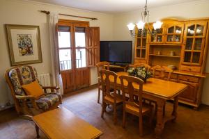 une salle à manger avec une table, des chaises et une télévision dans l'établissement CASA MERCEDES-PUERTOMINGALVO, à Puertomingalvo