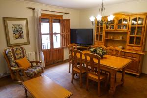 a dining room with a table and chairs and a television at CASA MERCEDES-PUERTOMINGALVO in Puertomingalvo