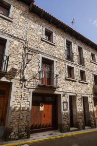 a stone building with a door and a balcony at CASA MERCEDES-PUERTOMINGALVO in Puertomingalvo