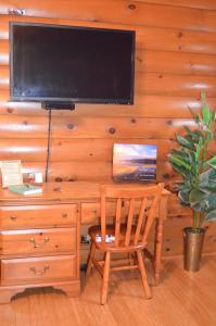 a wooden desk with a chair and a television on a wall at Serenity On The Lake in Auburn