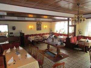 ein Esszimmer mit Tischen und Stühlen in einem Restaurant in der Unterkunft Hotel Zum Erker in Trebur