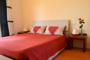 a bedroom with a bed with red sheets and two tables at B&B Sotto le Stelle in Fano