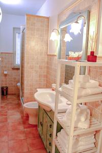 a bathroom with a sink and a toilet and a mirror at Casetta sulla Vallata in Pitigliano