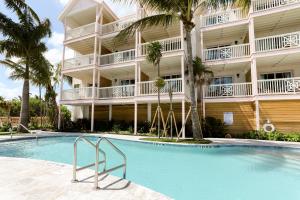 a hotel with a swimming pool in front of a building at Grassy Flats Resort & Beach Club in Marathon