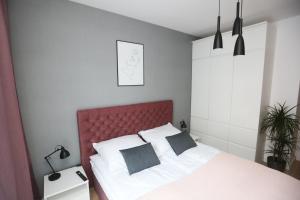 1 dormitorio con 1 cama grande y cabecero rojo en Bookowska 18 Apartment, parking free, check in 24h en Poznan