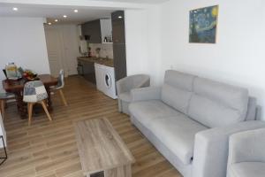 sala de estar con sofá y mesa en Mini villa T2 climatisée, vue mer, cosy & moderne, en Olmeto