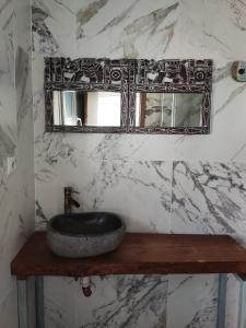 y baño con lavabo de piedra y espejo. en Villa Bali con jacuzzi climatizado y piscina climatizada con jacuzzi, en Chiclana de la Frontera