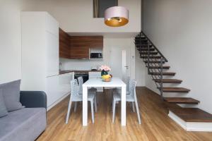 a kitchen and dining room with a white table and chairs at Prague Tales Boutique Residence in Prague