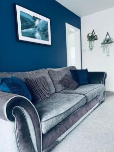 a couch in a living room with a blue wall at Dalkeith Five Bedroom House in Dalkeith