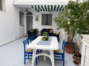 einen weißen Tisch und blaue Stühle auf einer Terrasse in der Unterkunft Casa Fiorella - Casa indipendente centro Anacapri in Anacapri