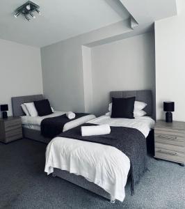 達奇斯的住宿－Dalkeith Five Bedroom House，一间卧室配有两张白色和黑色的床