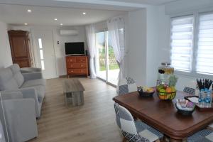 - un salon avec un canapé et une table dans l'établissement Mini villa T2 climatisée, vue mer, cosy & moderne, à Olmeto
