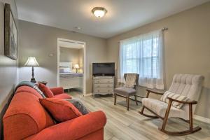 a living room with a red couch and a television at Centrally Located South Hill Apartment with Smart TV in Spokane