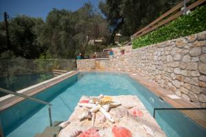 a swimming pool with a stone wall and a swimming pool at Villa Douros in Parga