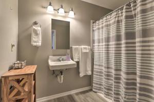 a bathroom with a sink and a shower curtain at Centrally Located South Hill Apartment with Smart TV in Spokane +18 photos